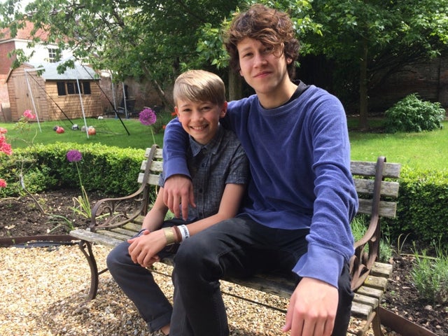Isaac Waddington on a bench in the garden with his arm around the shoulder of his little brother Jack, who is on the left.